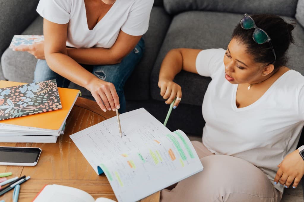 Two people reviewing notes together at a table